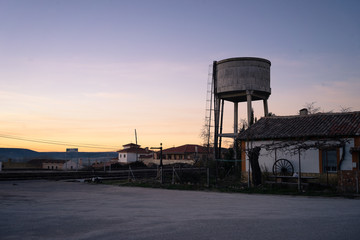 Water tank and old house. Inland village.