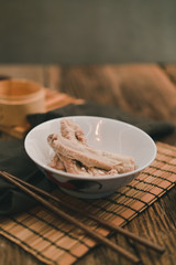 A cook is preparing a Bak kut teh for service to his customer in a Chinese restaurant.