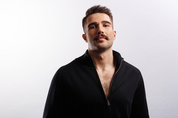 Obraz premium Portrait of a handsome bearded man wear in black jacket, looking at camera over white background.
