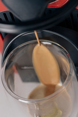 Pouring espresso coffee on a drinking glass