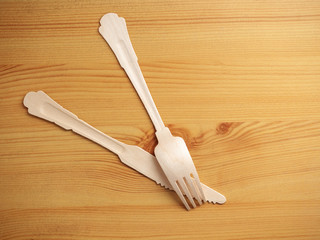 Wooden degradable fork and knife on a light wood table surface, Concept ecology and recycle issue.