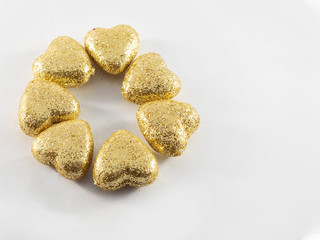 Golden glitter covered hearts on white background. Saint Valentine and love theme.