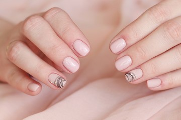 idea manicure creative light pink gel polish close-up with a pattern of black stripes and crystals