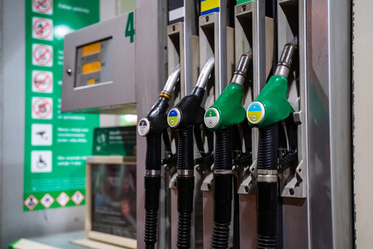 Gasoline And Diesel Distributor At The Gas Station. Gas Pump Nozzles. Petrol Filling Gun Close-up At The Gas Station. Colorful Petrol Pump Filling Nozzles. Fuel Pump