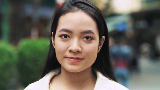 Handheld video shows of young Vietnamese woman looking at camera 