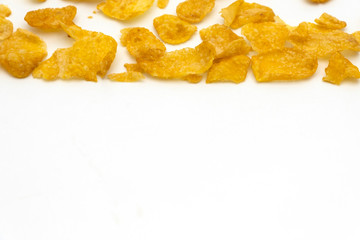Golden cornflakes splash on white background with copy space text