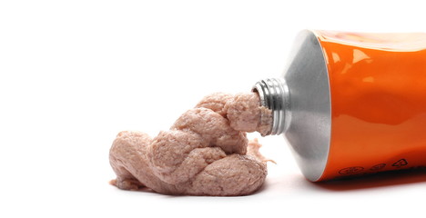 Liver pate coming out of tube packaging isolated on white background