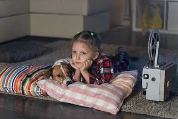 Girl child watching an old movie on a retro vintage film projector