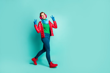 Full body photo of amazing lady enjoy winter day spend time walk street show v-sign symbols wear red overcoat blue scarf pink ear warmers pants boots isolated teal color background