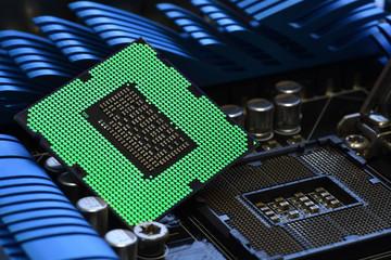 Detail of CPU Chip over socket of a modern computer motherboard with light effects.
