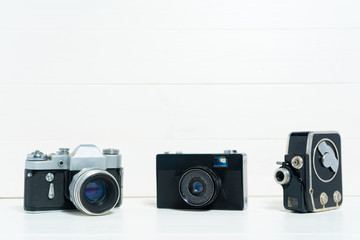 Vintage cameras on the white wooden background. Concept of old technology. Photo with place for...
