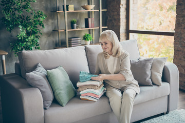 Portrait of her she nice attractive kind hardworking gray-haired granny sitting on divan folding...