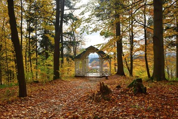 View of an old wooden gazebo with tree stumps in the foreground  and a view of the town of...