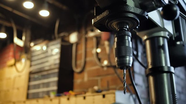 Close-up of a drill machine in a workshop. Carpentry wood processing factory.