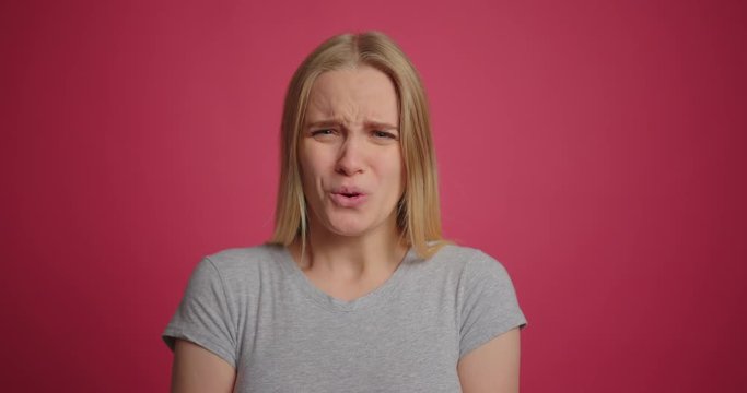 Blonde girl expressing disgust and disapproval with negative facial expressions