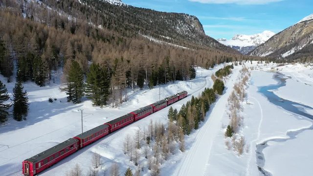 Bernina express on the railway in winter season. Valley of Morteratsch - Pontresina. Unesco Heritage.