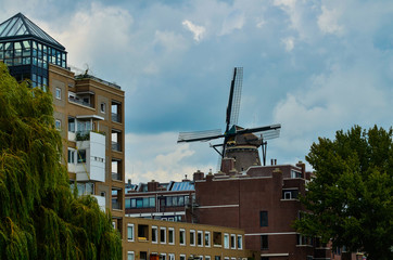 Amsterdam, Holland, August 2019.The De Gooyer Mill is located on the edge of the historic center:it is used as a brewery.Perfectly intact it is a dip in the past in the city.Blue sky with white clouds