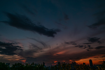 Natural Sunset in evening downtown silhouette at bangkok. .Bright Dramatic Sky And Dark Ground. city Landscape Under Scenic Colorful Sky At Sunset. Sun Over Skyline, Horizon. Light blue background.