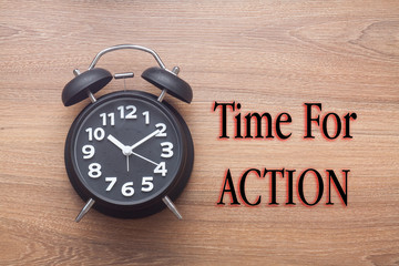 Concept,alarm clock with time for action written on wood background