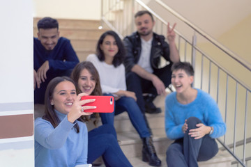 Multiethnic group of students sitting on school stairs smiling. Students taking a break on the steps at the university