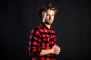 Archetypal image of Americans abroad. Masculinity and brutality concept. Adopt cowboy mannerisms as a fashion pose. Cowboy life came to be highly romanticized. Man unshaven cowboy black background