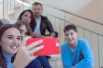 Multiethnic group of students sitting on school stairs smiling. Students taking a break on the steps at the university