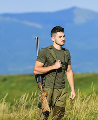 Man observing nature background. Hunter hold rifle. Hunter handsome guy with weapon. Brutal...