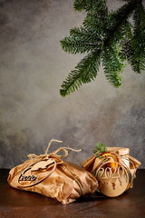 Gift in craft paper the Bank is covered with craft paper and tied with twine they are tied with medallions in the form of new year symbols a fir mouse and the numbers 2020 above them hangs a branch of