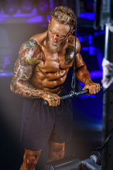 Fototapeta na wymiar Strong Handsome Bodybuilder Exercise in the Gym