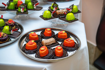 Different sort of beautiful pastry, small colorful sweet cakes