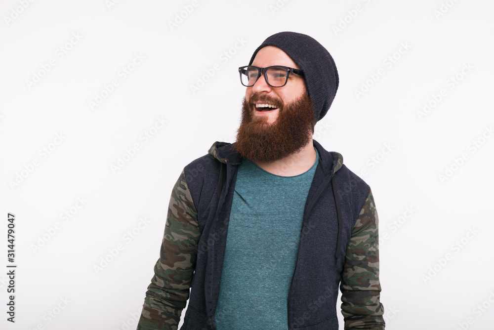 Wall mural portrait if smiling young bearded man looking away