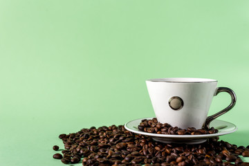 Coffee cup and coffee beans on a light mint background
