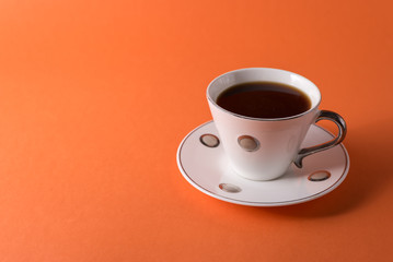  cup of aromatic coffee on an orange trendy background with space for text