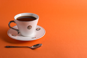  cup of aromatic coffee on an orange trendy background with space for text