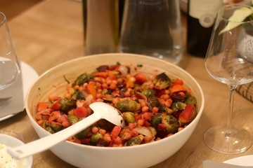 Bowl of salad with chickpeas and roasted vegetables, served on a table. Selective focus.