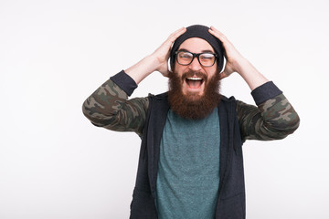 Photo of amazed bearded man screaming over white background