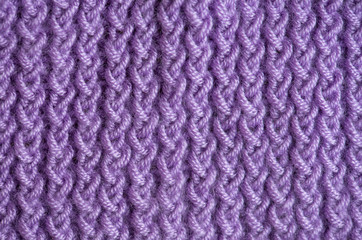 Close-up, violet handmade knitting fabric texture background.