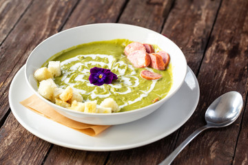 Pottage stew with green vegetables pieces of bread and sausage slices