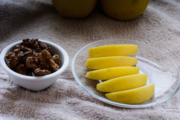 walnuts and slices of yellow apples on a table