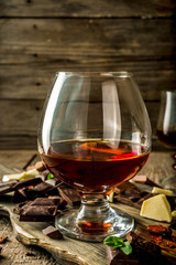 Strong alcohol drink. Glass of brandy, whiskey or cognac on the wooden table