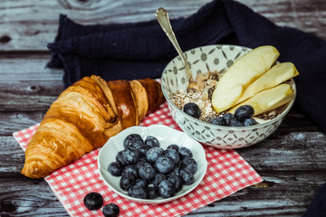 Petit déjeuner sain avec croissant muesli pommes et myrtilles