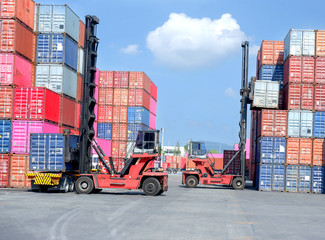 Container handlers are loading containers into trucks.