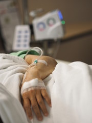 Patients sleep on the bed ward set IV saline solution in female hand at hospital