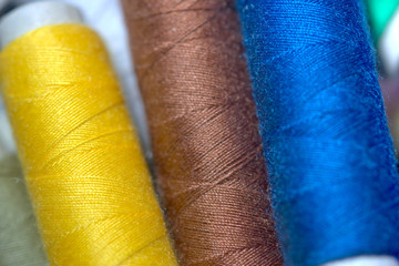 spools of thread on wooden background