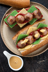 Above view of submarine sandwiches with meatballs on a beige plate, vertical shot, closeup