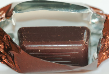 A close up view of chocolate candy in a brown wrap.