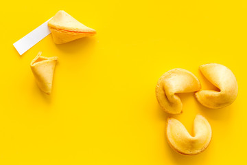 Traditional fortune cookies on yellow table top-down copy space