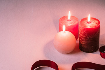 Three wax flame candlelight with red ribbon on white background, love dating, Valentine's day, selective focus