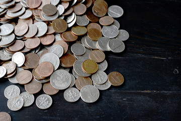 A pile of American cents on an old black wooden surface close-up. Money background