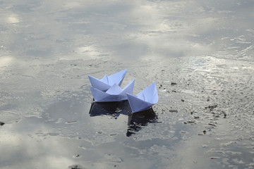  paper boats sail on frozen water